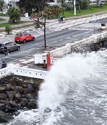 Maré elevada e ondas fortes atingem trecho de orla durante frente fria no litoral paulista